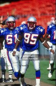 Two professional football players in red, white, and blue uniforms.